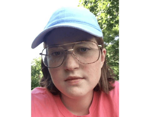 A girl wearing glasses and a hat named Rebekah Lourcey